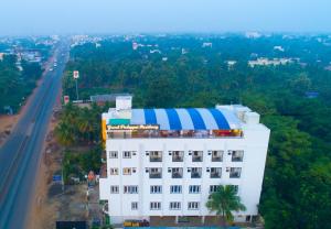 a white building with a blue and white stripe on it at Grand Padappai Residency in Chennai