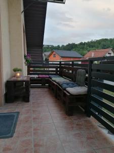 eine Terrasse mit Bänken und einem Tisch auf dem Balkon in der Unterkunft Hostel Poslon in Krapina