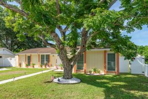 een huis met een boom in de tuin bij The Flamingo*4bed*pool*jacuzzi*foosball in Valrico