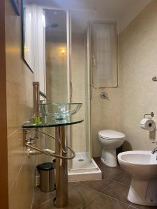 ein Badezimmer mit einem Glaswaschbecken und einem WC in der Unterkunft Ulivo Apartment in Trapani