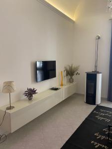 ein Wohnzimmer mit einem TV an einer weißen Wand in der Unterkunft Ulivo Apartment in Trapani