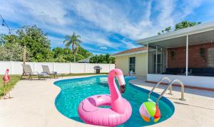 a swimming pool with a pink flamingo in the water at The Flamingo*4bed*pool*jacuzzi*foosball in Valrico