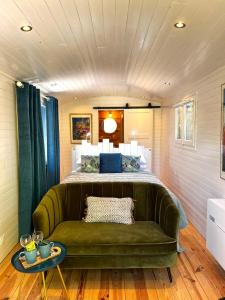 a bedroom with a green couch in front of a bed at La Magnanerie d'Hôtes ,le jardin secret in Sauve