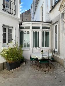 a patio with a table and chairs in front of a building at Lysbed - Desjardins in Angers