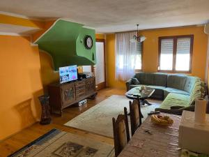 a living room with a couch and a clock on the wall at Apartment Cuni in Mostar