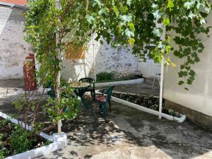 a patio with a table and chairs under a tree at Apartment Cuni in Mostar