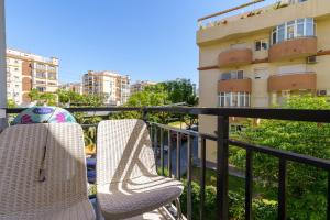 a balcony with two chairs and a building at CT 178 - Versalles City Apartment - Fuengirola in Fuengirola