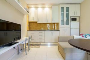 a kitchen with white cabinets and a table at CT 178 - Versalles City Apartment - Fuengirola in Fuengirola