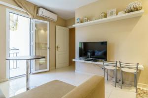 a living room with a television and a table and chairs at CT 178 - Versalles City Apartment - Fuengirola in Fuengirola