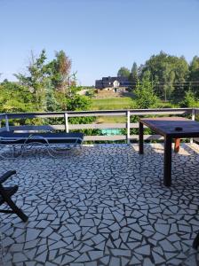 a picnic table and a bench on a patio at Sawanna in Gołubie