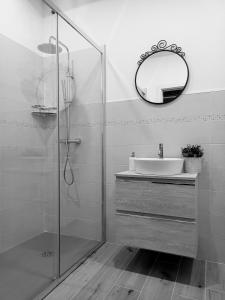 W łazience znajduje się umywalka i lustro. w obiekcie B&B Il Ghiro w mieście Riolunato
