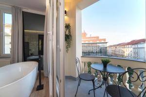 een badkamer met een bad en een tafel en stoelen bij Liberty Apartments, 3rd Floor, no elevator in Zagreb