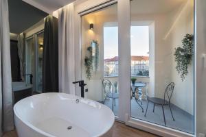 a bathroom with a tub and a balcony with a table at Liberty Apartments, 3rd Floor, no elevator in Zagreb