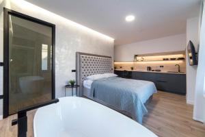 een slaapkamer met een bed en een badkamer met een bad bij Liberty Apartments, 3rd Floor, no elevator in Zagreb