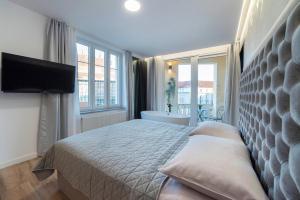 een slaapkamer met een bed, een bad en een televisie bij Liberty Apartments, 3rd Floor, no elevator in Zagreb