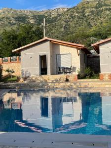 a house with a swimming pool in front of a house at VILA LLANO in Vlorë