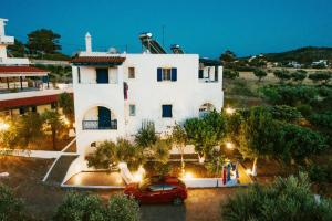 a red car parked in front of a white building at Theofilos Appartements in Livadi