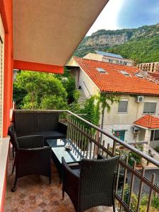 a balcony with chairs and a table and a building at Apartmani Jankovic in Budva