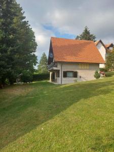 a house with an orange roof in a yard at Kuca za odmor Zlatibor in Zlatibor