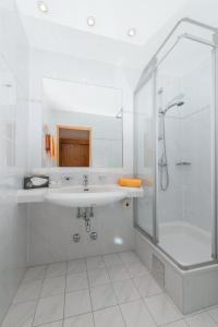 a white bathroom with a sink and a shower at Greiner's Ferienzimmer Tauplitz in Tauplitz