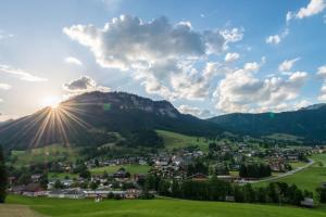 a small town in the mountains with the sun setting at Greiner's Ferienzimmer Tauplitz in Tauplitz