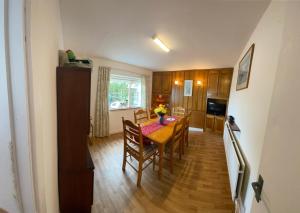 een keuken en eetkamer met een tafel en stoelen bij Maisie's Seaside Cottage in Quilty