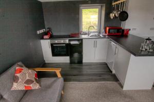 pequeña cocina con sofá y encimera en Whitewave Apartment en Monkstadt