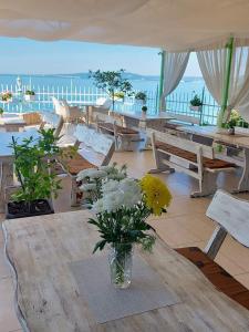 a vase of flowers sitting on a table in a patio at Hotel Oasis - Beach Access in Balchik