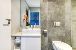 a bathroom with a sink and a toilet at Backup-Powered Colourfull City Balcony Apartment in Cape Town