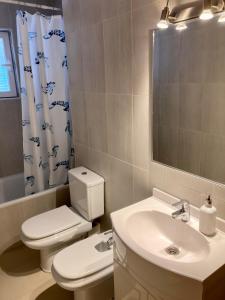 uma casa de banho com um WC, um lavatório e um espelho. em 2 baños! Piso grande 100 m2 y Garaje gratis em Madri