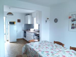 cocina con mesa y nevera blanca en Grande maison de 4 chambres, 9 couchages proche du Mont Saint Michel, en Saint-James