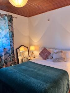 um quarto com uma cama grande com um cobertor verde em Alojamento Local S. Bartolomeu em Trancoso