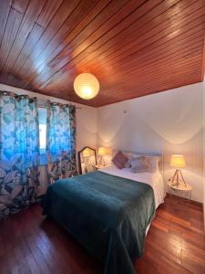 um quarto com uma cama grande e um teto de madeira em Alojamento Local S. Bartolomeu em Trancoso