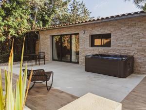 a hot tub on a patio next to a building at Lodge coocon & SPA in Nîmes
