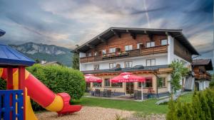 um hotel com um parque infantil em frente a um edifício em Familienhotel Central em Sankt Johann in Tirol