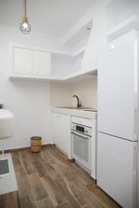 a kitchen with white appliances and a wooden floor at GRΕΛΙΑ ΗΟΜΕ in Naxos Chora