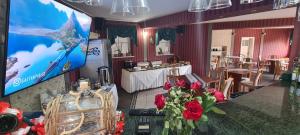 a room with a tv and a table with flowers at Apartamenty Hexagon 7 in Grzybowo