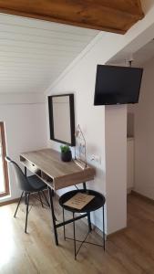 a desk with a mirror and two chairs in a room at Къща Катерков in Sozopol