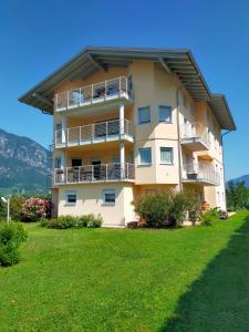 a tall building with balconies and a grass field at Bed and Breakfast La Cesura in Mattarello