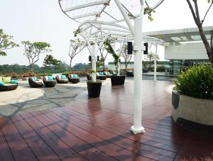 - une terrasse avec un bouquet de plantes en panneaux et un parasol dans l'établissement U Residence Tower2 Supermal Lippo Karawaci, à Klapadua