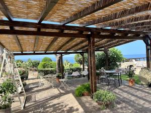 a wooden pergola with a table and chairs at Villa Sebastian- Incomparabile vista sul mare in Siracusa