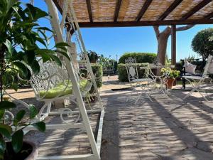 a group of white chairs sitting on a patio at Villa Sebastian- Incomparabile vista sul mare in Siracusa
