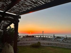 a sunset over the ocean with chairs on a patio at Villa Sebastian- Incomparabile vista sul mare in Siracusa