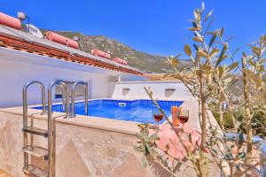 a villa with a swimming pool and a house at Olive View Penthouse in Kalkan