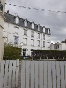 Biały budynek z płotem przed nim w obiekcie L'annexe w mieście Cabourg +17 zdjęć