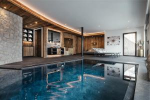 an indoor pool in a house with a living room at Luxury Chalet Lefiro in Santa Cristina in Val Gardena