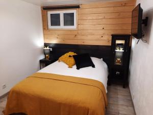 a bedroom with a bed with a yellow blanket at Charmant logement avec terrasse et billard in Zimmerbach