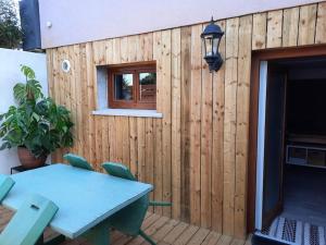 a wooden fence with a table and a window at Charmant logement avec terrasse et billard in Zimmerbach