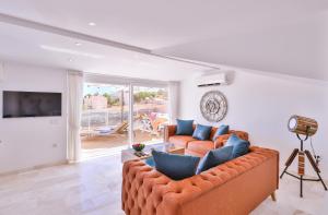 a living room with a couch and a television at Olive View Penthouse in Kalkan
