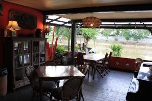 a restaurant with tables and chairs and a large window at The Riverside Guest House in Lampang